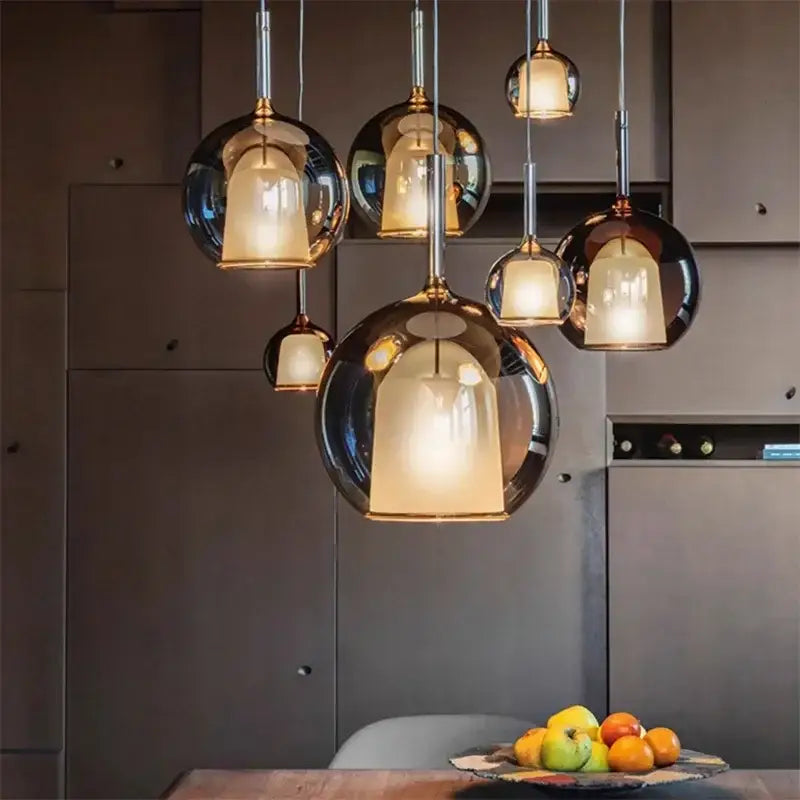 Modern metallic spherical designer glass chandelier pendant light with warm glowing interiors for elegant dining room decorbites design