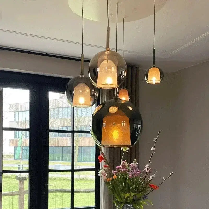 Modern metallic spherical pendant light with reflective glass shades and warm glow decorbites designer glass chandelier