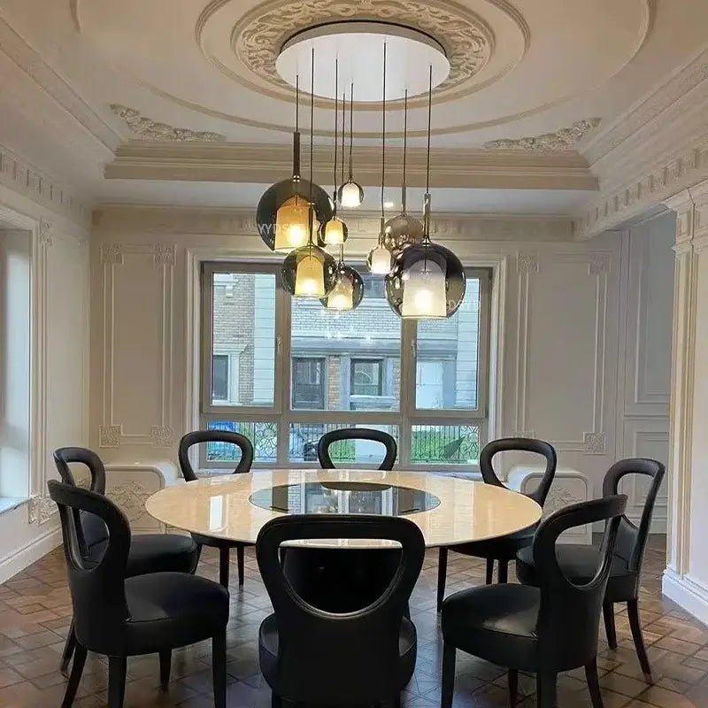 A modern metallic spherical designer glass chandelier pendant light with multiple glass shades hanging from a ceiling medallion