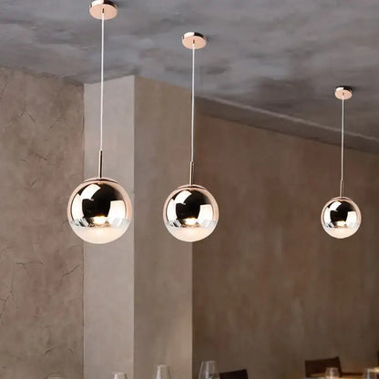 Three sleek metallic ball pendant lights with polished chrome finish for modern living room lighting