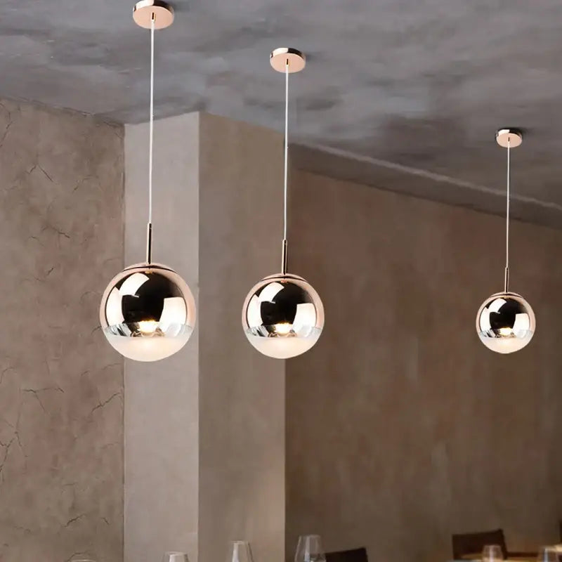Three sleek metallic ball pendant lights with polished chrome finish for modern living room lighting