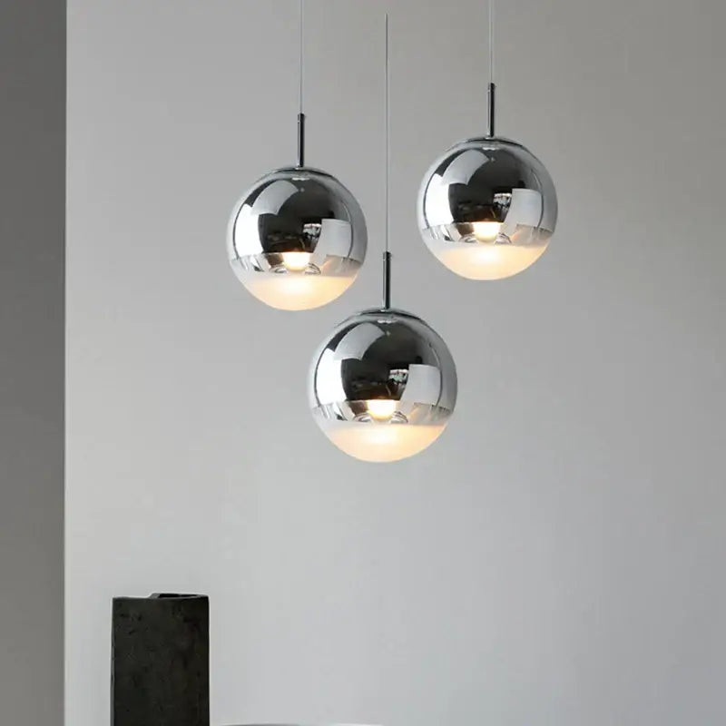 Modern metallic tri color ball pendant lights with sleek chrome finish and warm glowing interiors for living room