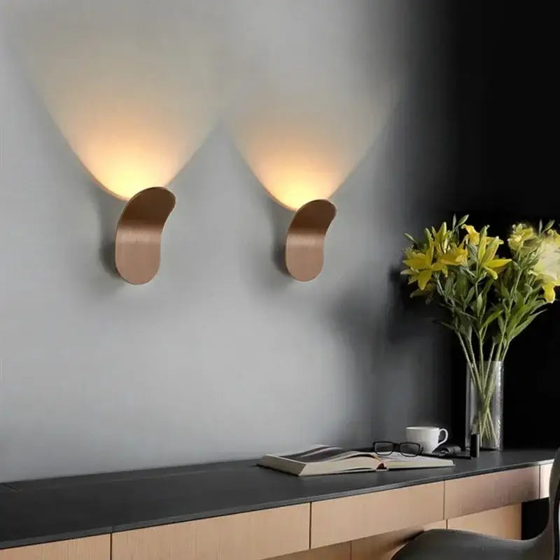 Pair of modern minimalist copper-toned decorbites adjustable cob led wall lights casting warm light for bedroom sconce