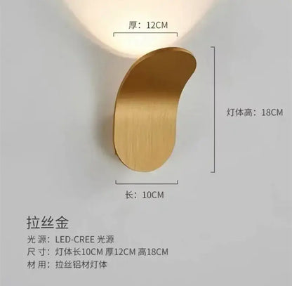 A sleek brushed gold wall light with modern crescent design and integrated adjustable cob led for bedroom decorbites