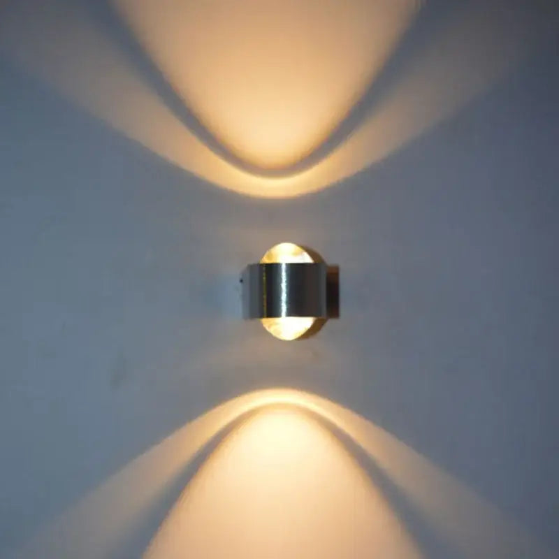Modern minimalist aluminum led wall lamp with sleek metallic finish and warm focused lighting casting curved shadows