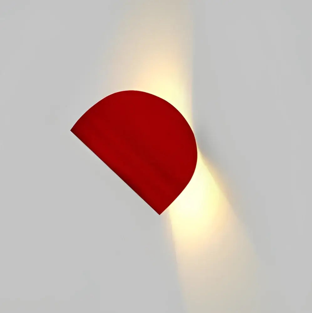 A sleek vibrant red semi-circular wall lamp with matte finish from decorbites art decor rotating collection for bedroom use