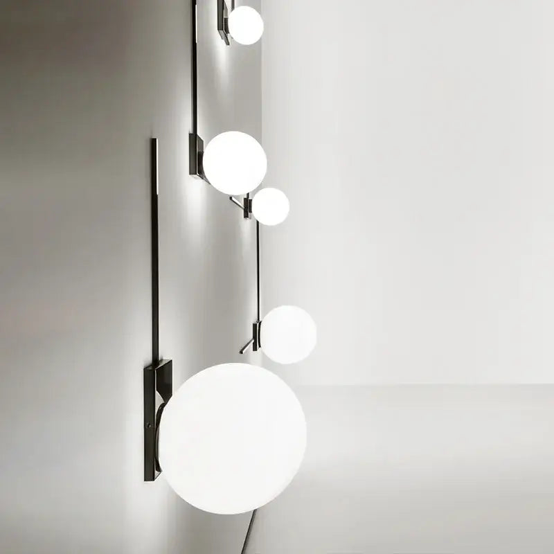 Modern minimalist black wall lights with sleek metal frame and five frosted white glass ball globes for bedroom use
