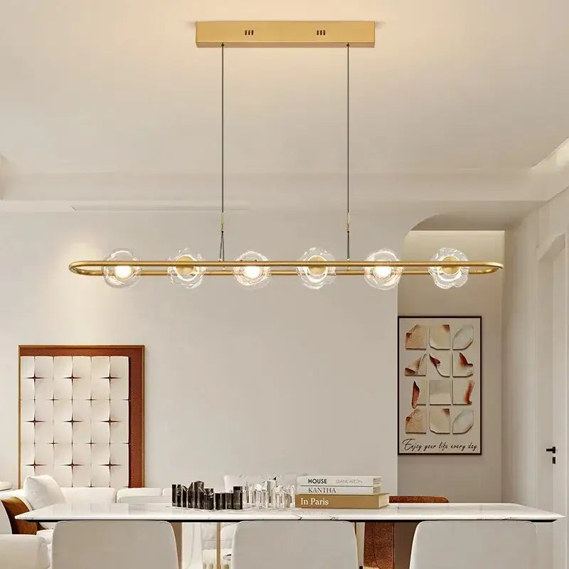 Modern gold-toned pendant light with five clear glass globe bulbs in sleek led chandelier pendant for bedroom use
