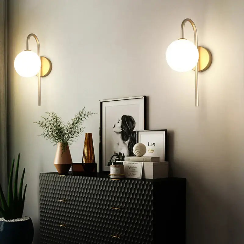 Modern gold-toned led wall lamp with spherical frosted glass shades for minimalist bedroom lighting