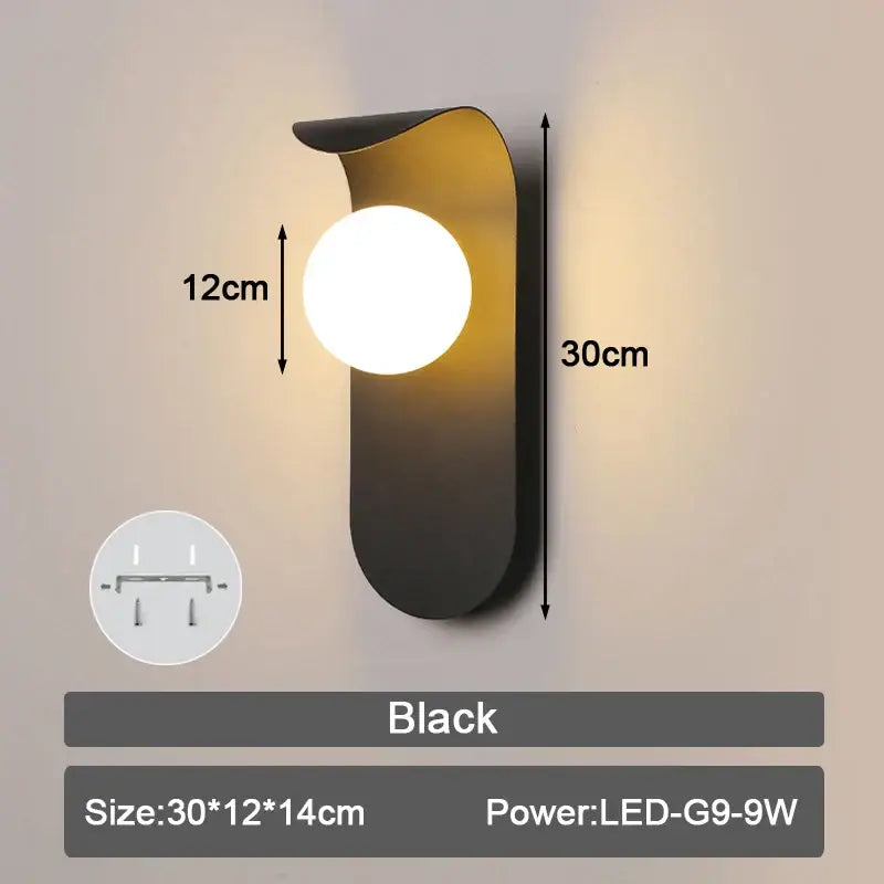 Black modern led wall lamp with sleek curved metal body and round frosted glass lampshade for bedroom use