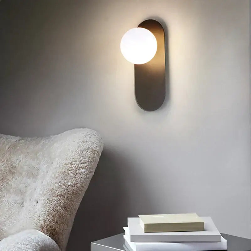 Modern minimalist led wall lamp with matte gold backplate and frosted glass spherical bulb for bedroom use