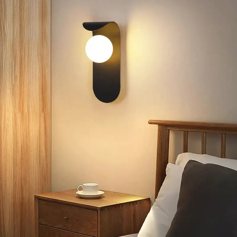 Modern minimalist black led wall lamp with gold accents and frosted glass bulb for bedroom lighting
