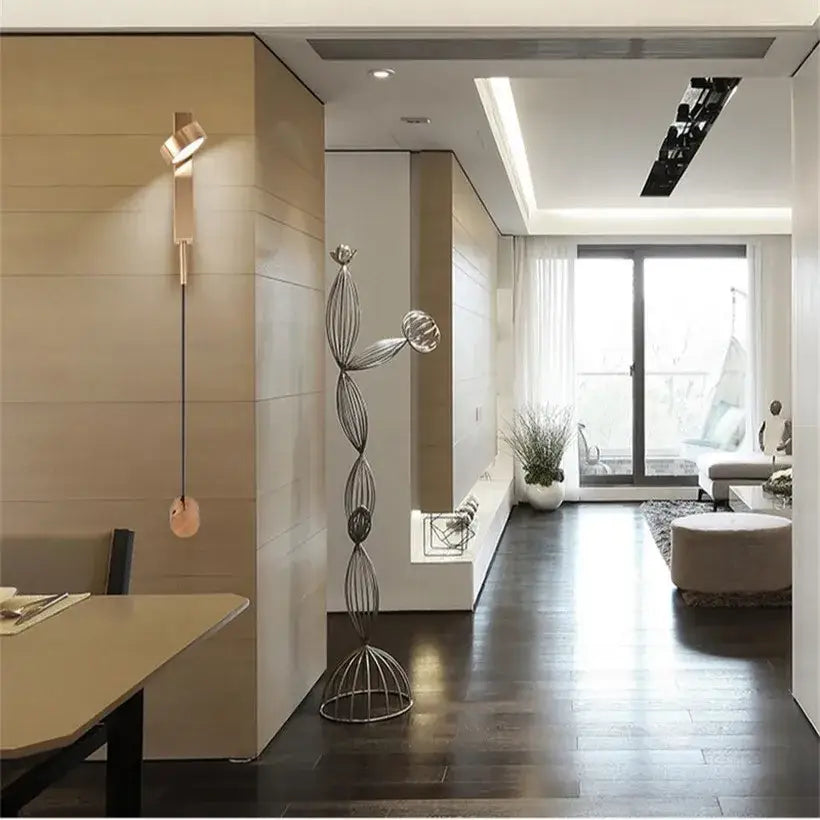 Modern minimalist black and gold metallic wall light sconce with abstract interlocking wire loops and spherical elements