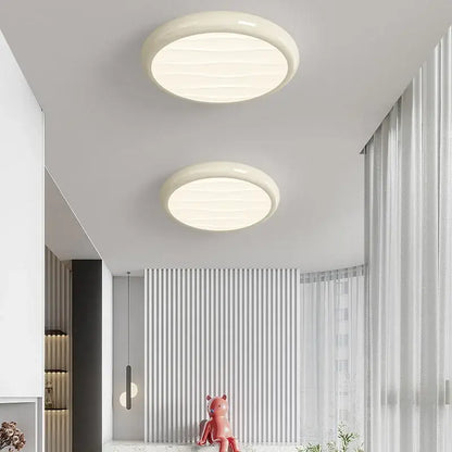 Two off-white circular decorbites led ceiling lights with smooth textured surface for modern minimalist bedroom decor