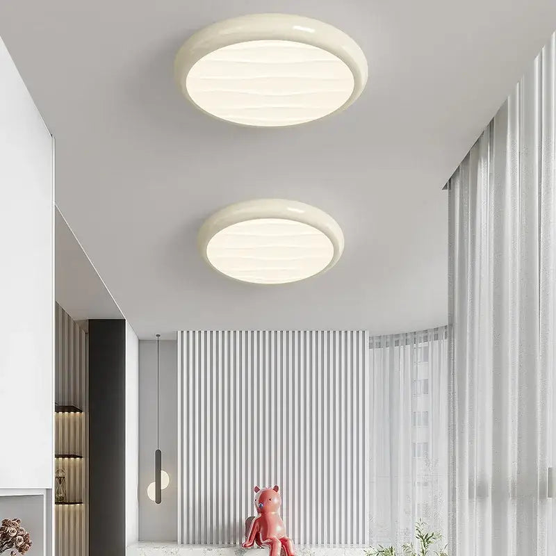 Two off-white circular decorbites led ceiling lights with smooth textured surface for modern minimalist bedroom decor