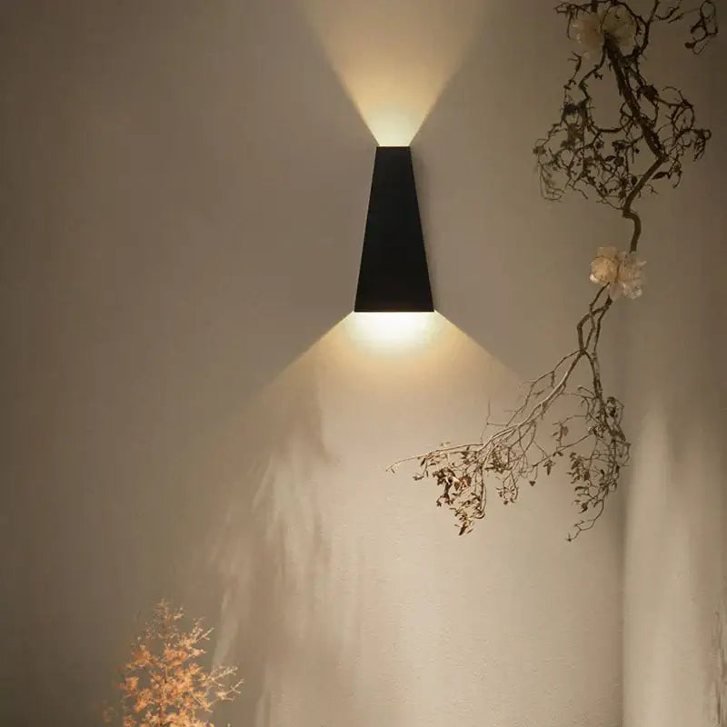 Black minimalist led wall lamp with sleek angular design casting warm focused light for bedroom reading
