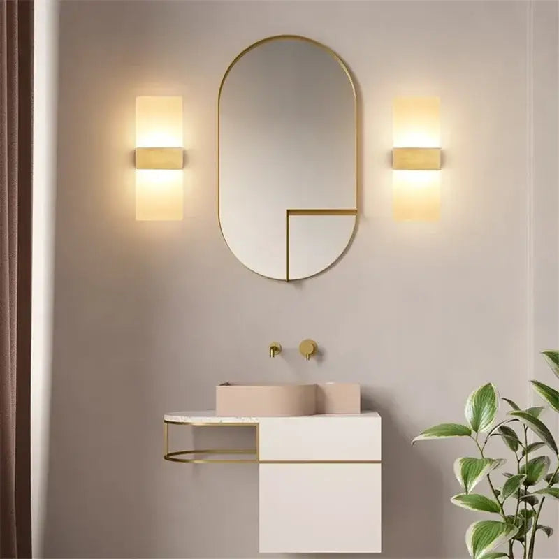 Gold-framed oval mirror with geometric cutout design paired with modern minimalist black led wall light bedroom sconce decorbites led wall