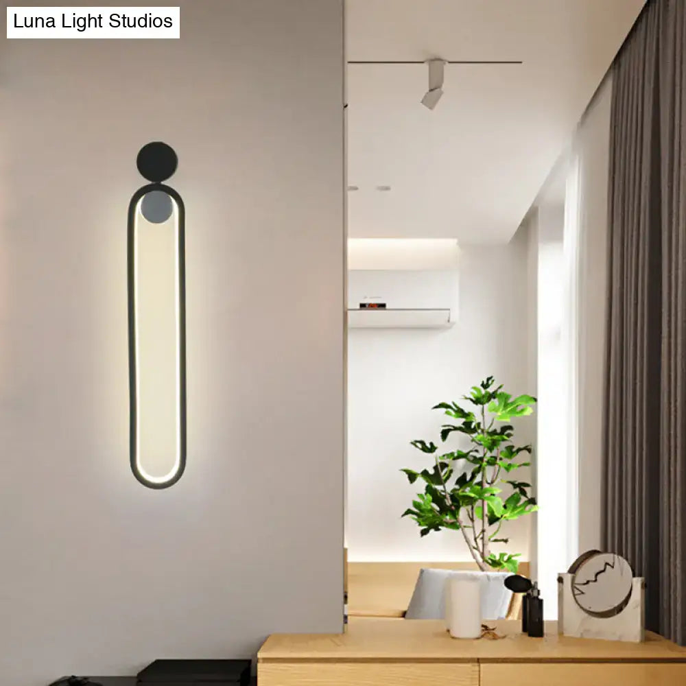 Modern minimalist black led wall sconce with sleek oval light panel and circular accents for bedroom and living room