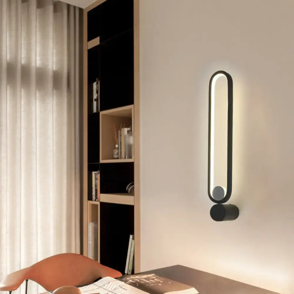 Modern minimalist black led wall sconce with sleek oval design providing soft ambient lighting for bedroom and living room
