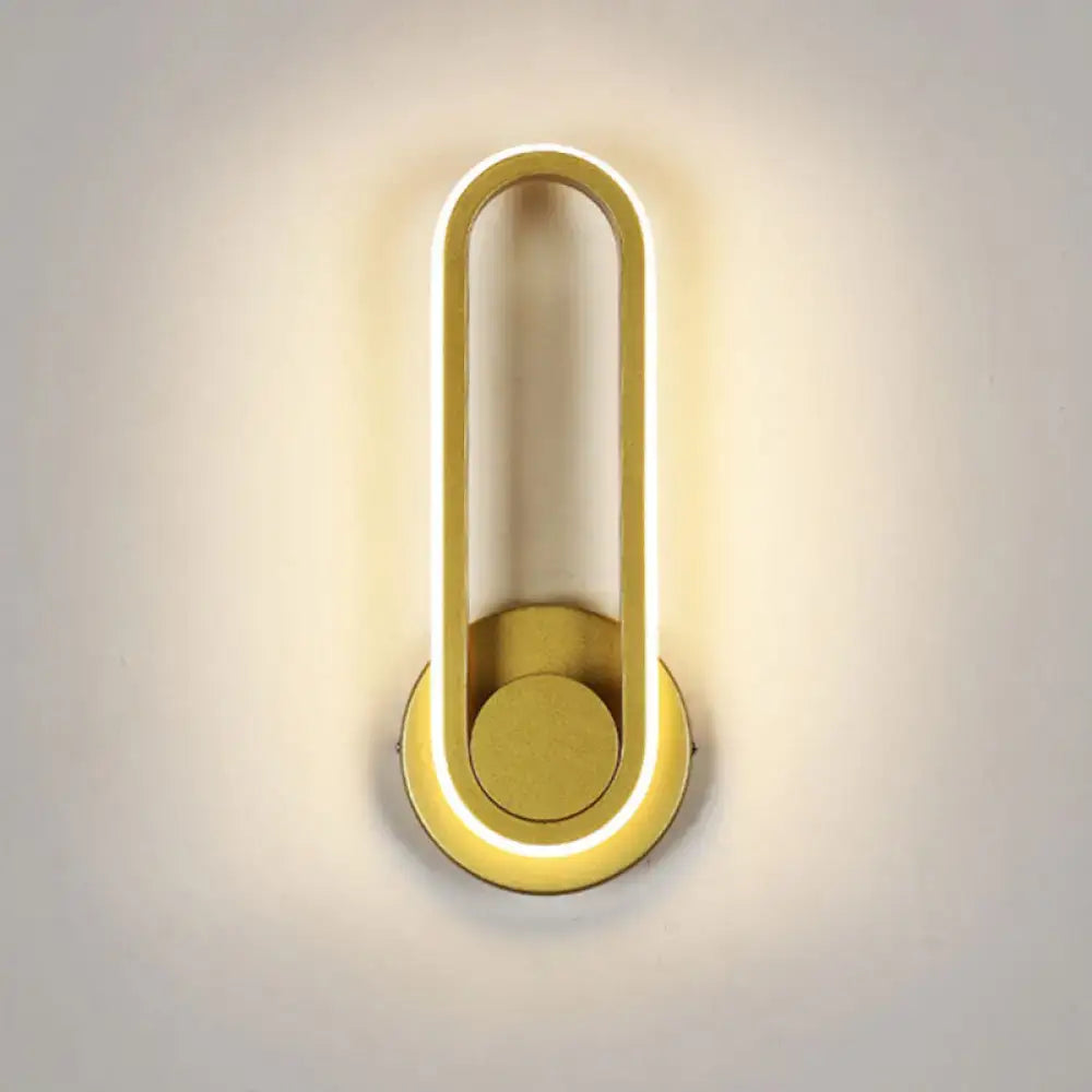 Modern minimalist gold-toned oval led wall sconce with sleek frame and natural colors for living room lighting