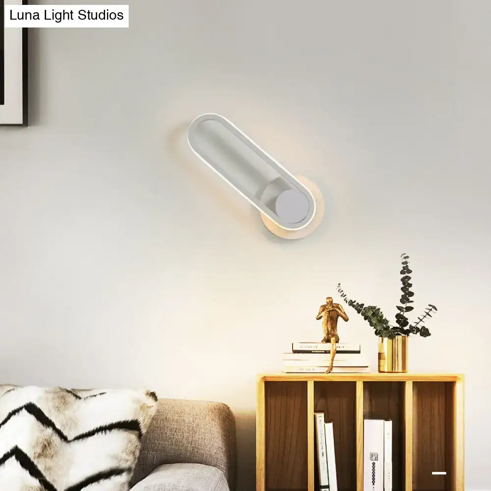 Modern minimalist black matte oval led wall sconce with elongated translucent glass shade and matte white base in natural colors