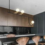 Modern minimalist ceiling light with three frosted glass globes on black metal arm for dining room fixture height