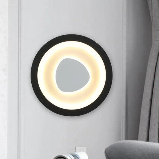 Modern minimalist black wall light with acrylic shade featuring a glowing warm white ring and irregular mirror for bedroom