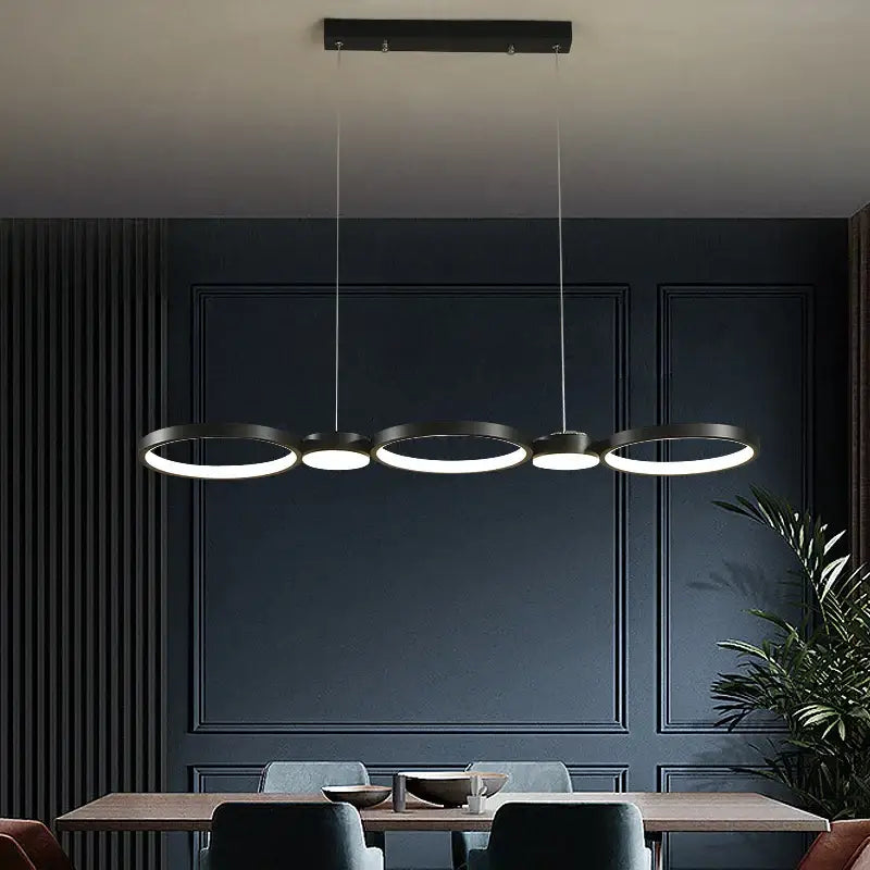 Modern minimalist black ring led chandelier with illuminated rings suspended above dining table decorbites black ring