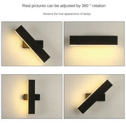 Modern minimalist black rotate wall lamp with two intersecting bars emitting warm light for bedside reading