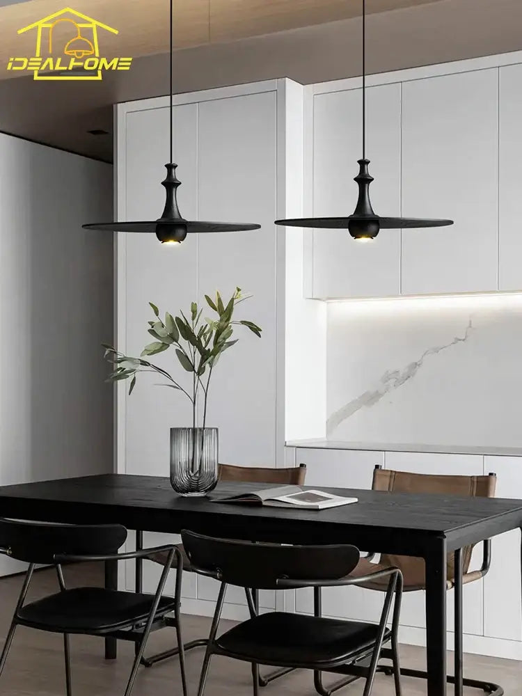 Modern minimalist black solid wood pendant lights with black matte finish hanging above dining table decorbites black solid