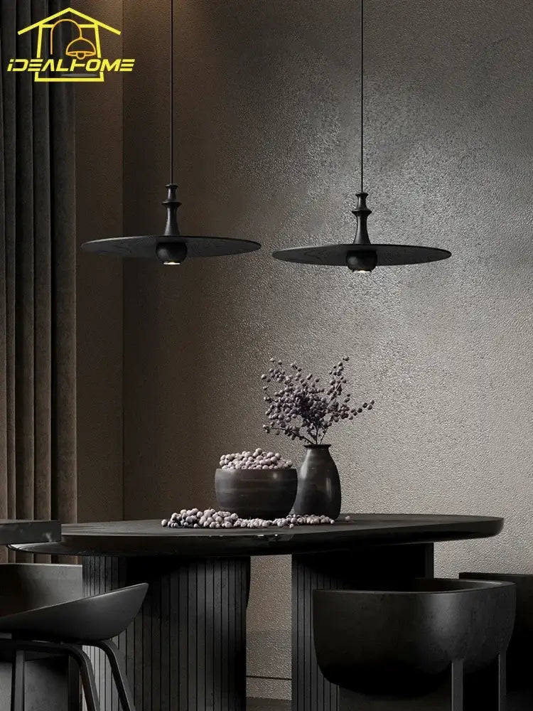 Two sleek black solid wood pendant lights with minimalist disc-shaped shades for modern dining room decorbites decor