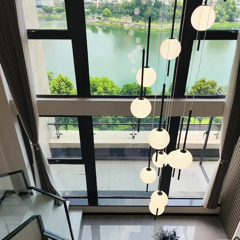 Modern minimalist black and white creative led chandeliers featuring white spherical pendant lights with black rods by decorbites creative