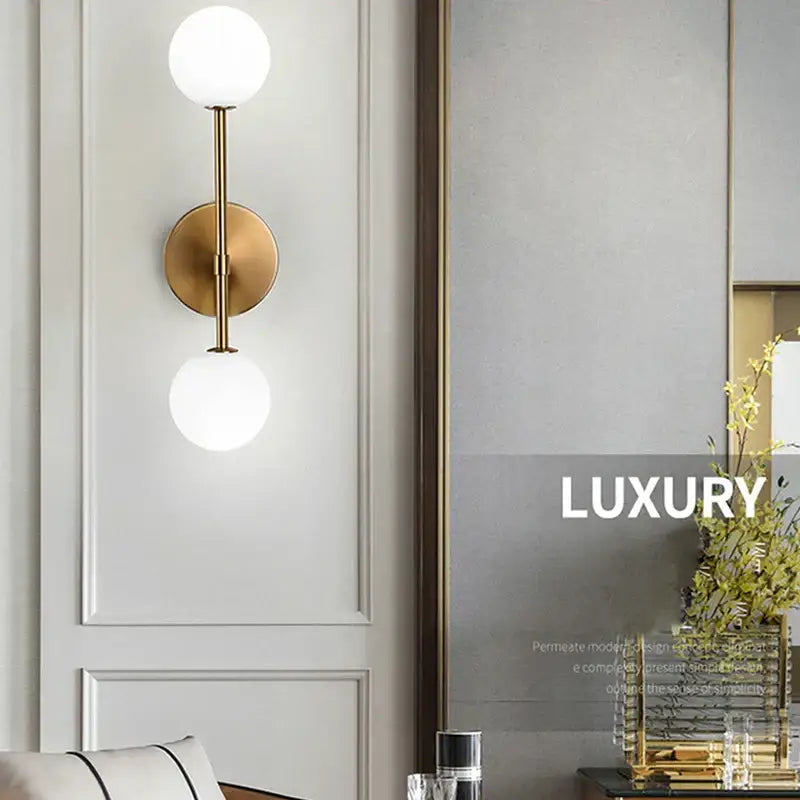 Gold-toned wall lamp with two spherical frosted glass ball shades for modern minimalist led wall lamp use