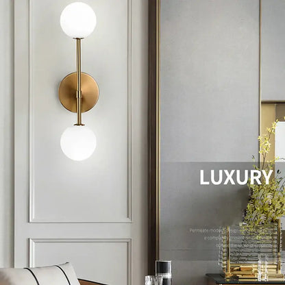 Gold-toned wall lamp with two spherical frosted glass ball shades for modern minimalist led wall lamp use