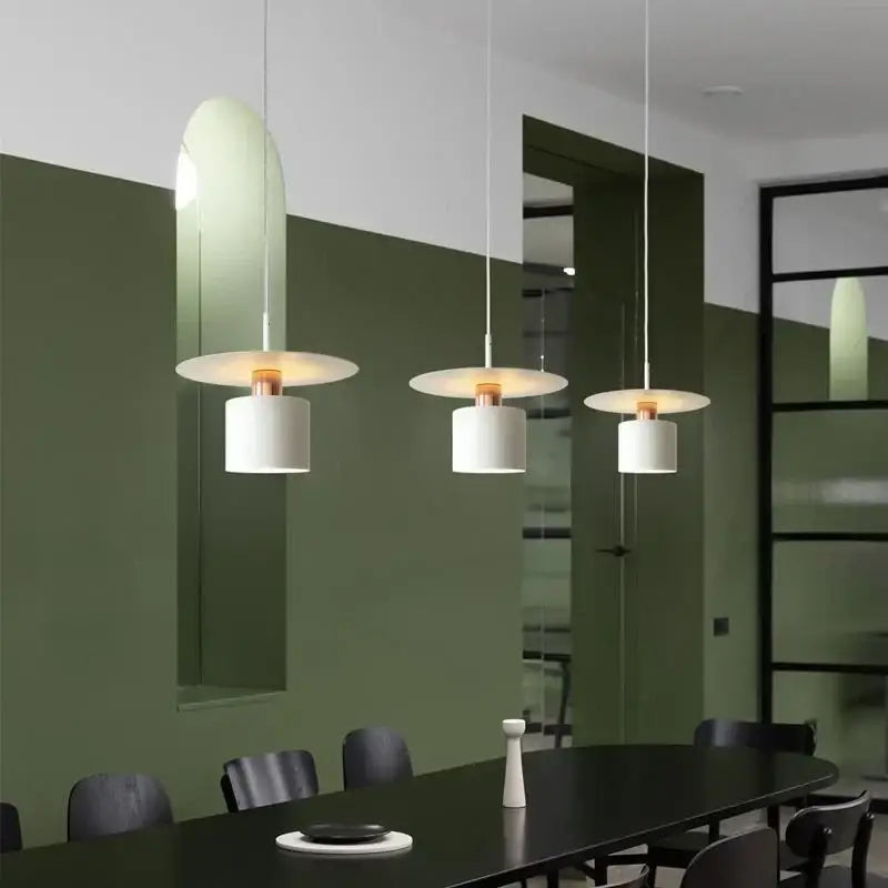 Three modern white cylindrical pendant lights with copper accents for elegant led pendant kitchen lighting
