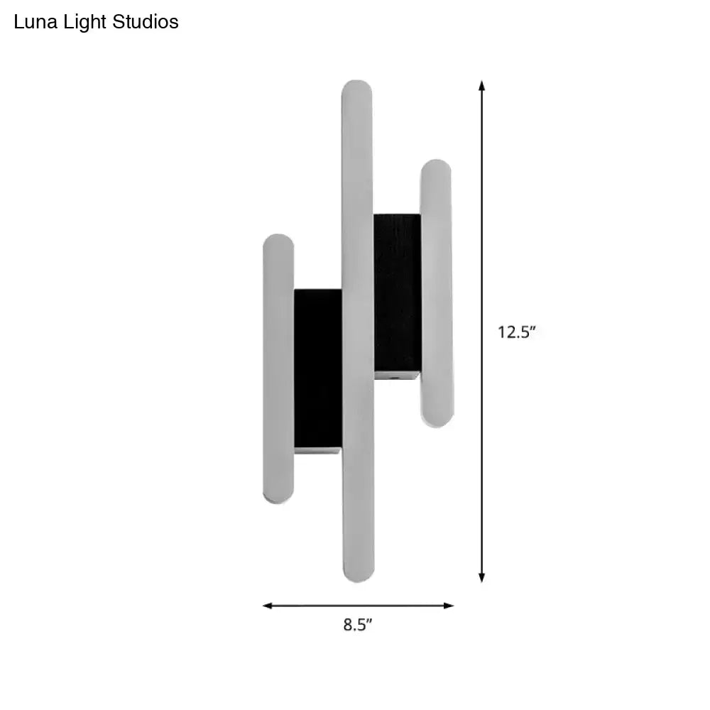 Modern minimalist black and white led wall sconce with sleek silver and black panels providing warm white light