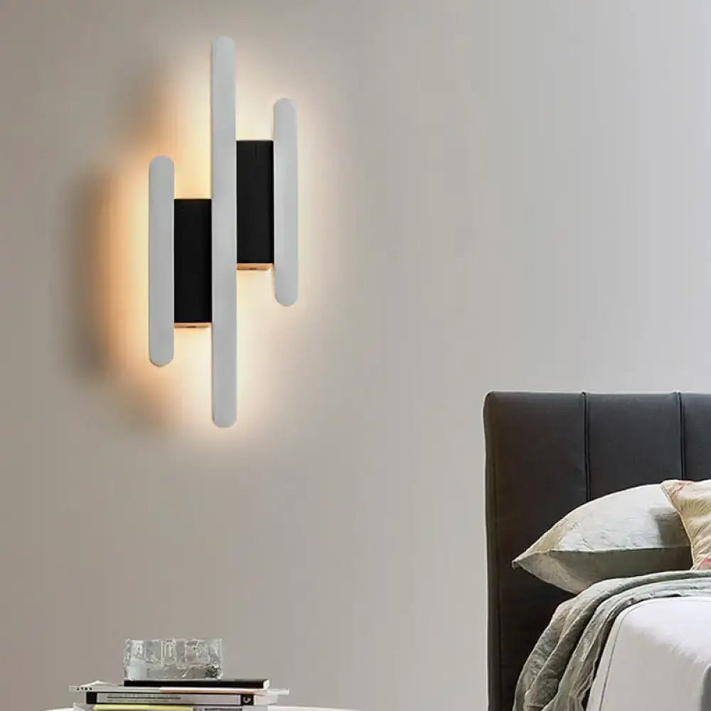 Modern minimalist black and white led wall sconce with three vertical acrylic bars and warm white ambient light