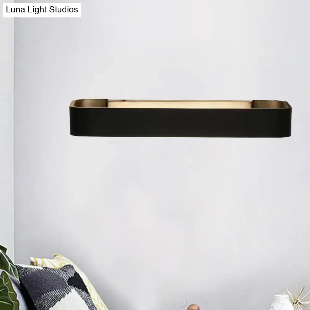 Modern minimalist black and white rectangular wall lamp with sleek metallic frame and warm ambient lighting for bedroom use