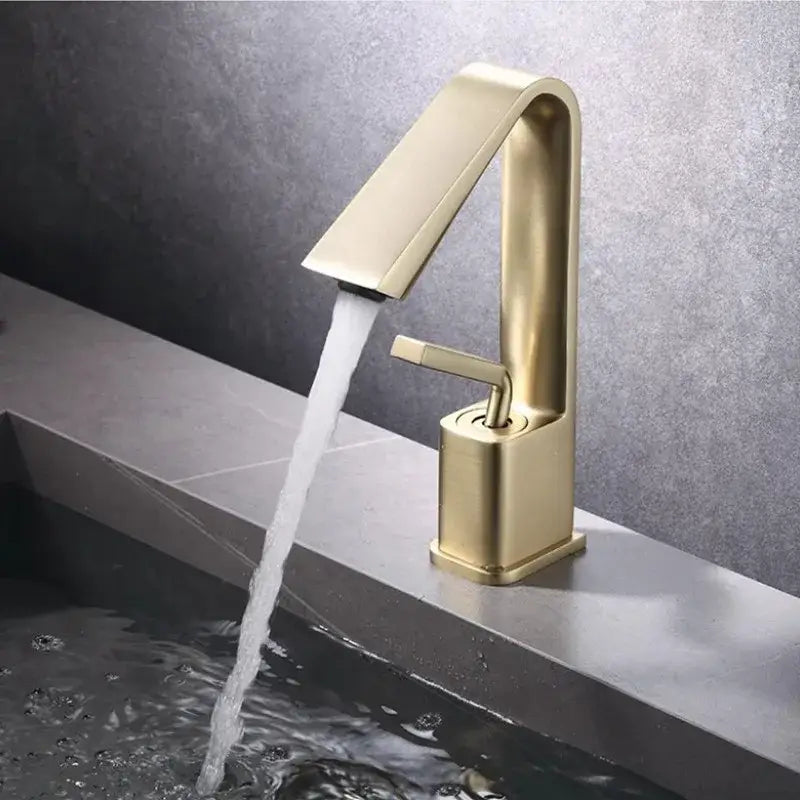 Modern minimalist brush gold basin faucet with sleek gold-toned design and single handle for flow control by Decorbites