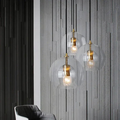 Three modern pendant lights with clear glass ball domes and brass accents for dining room decorbites clear glass