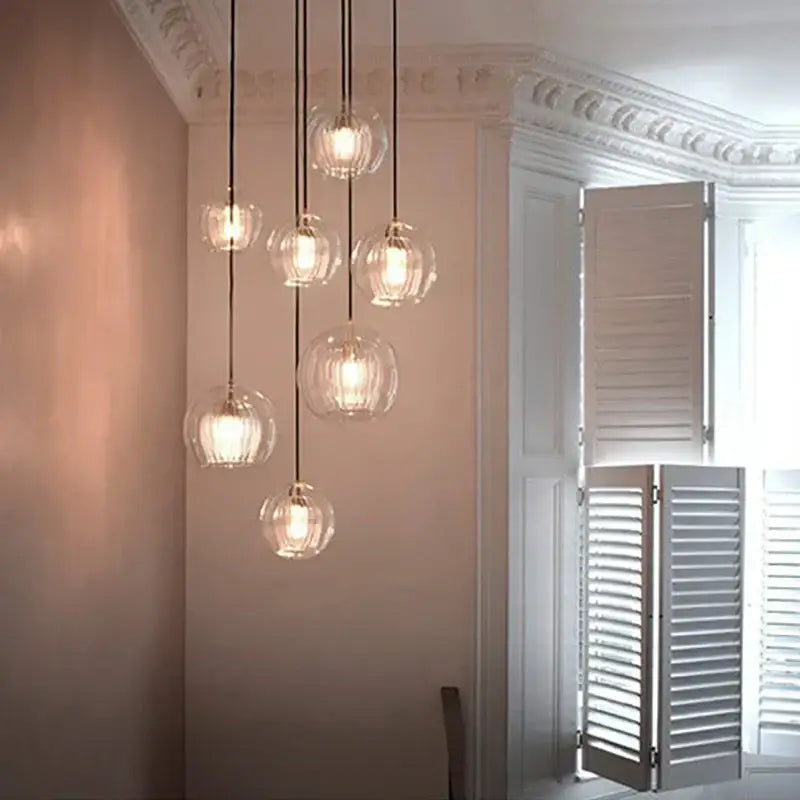 Modern minimalist clear glass ball pendant light with black cords by decorbites for dining room decor