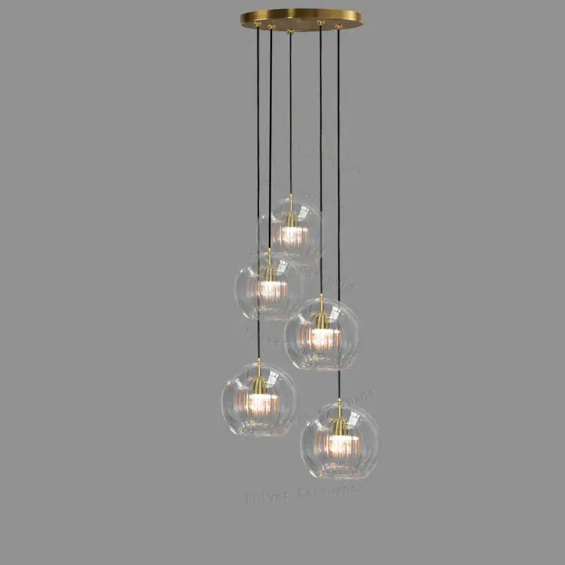 Modern minimalist pendant light with five clear glass ball shades and brass finish for dining room decorbites clear glass