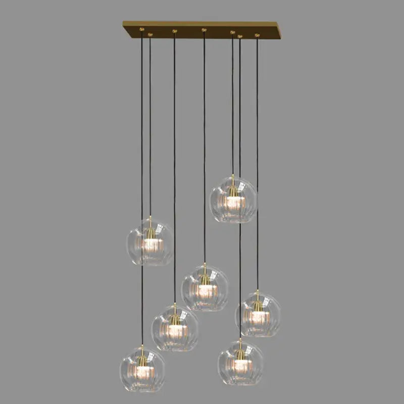 Modern minimalist brass rectangular pendant light with seven decorbites clear glass ball globes for dining room decor