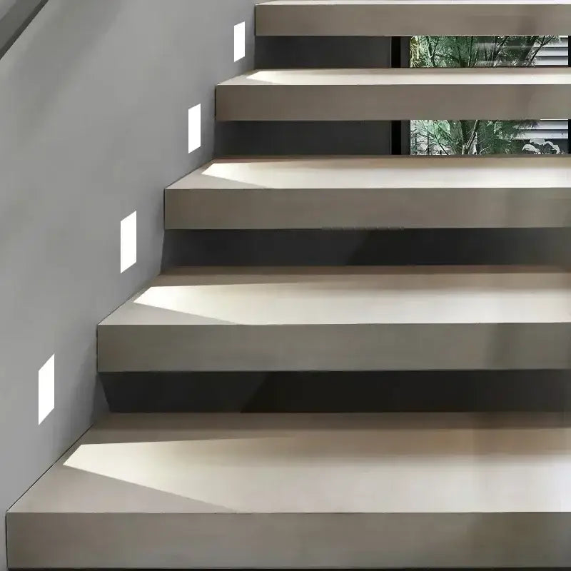 Modern minimalist concrete staircase with clean floating steps illuminated by led underground lamp lighting