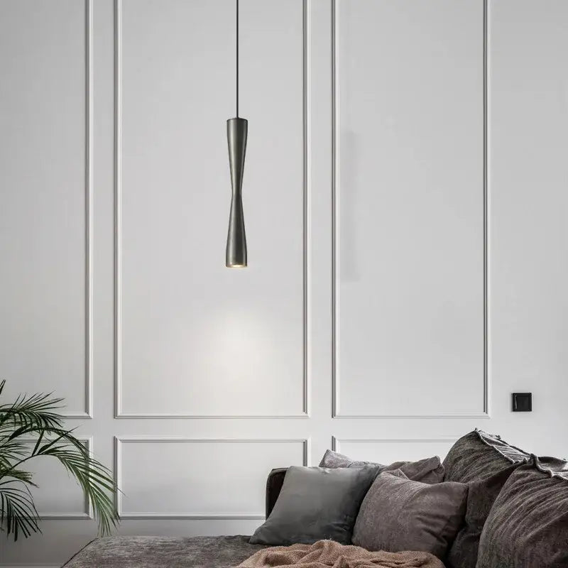 A sleek dark gray modern minimalist copper black gold pendant light with an elongated hourglass shape for dining room decorbites