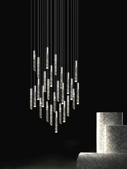 Modern minimalist crystal chrome led chandelier featuring slender etched cylindrical elements with warm ambient lighting