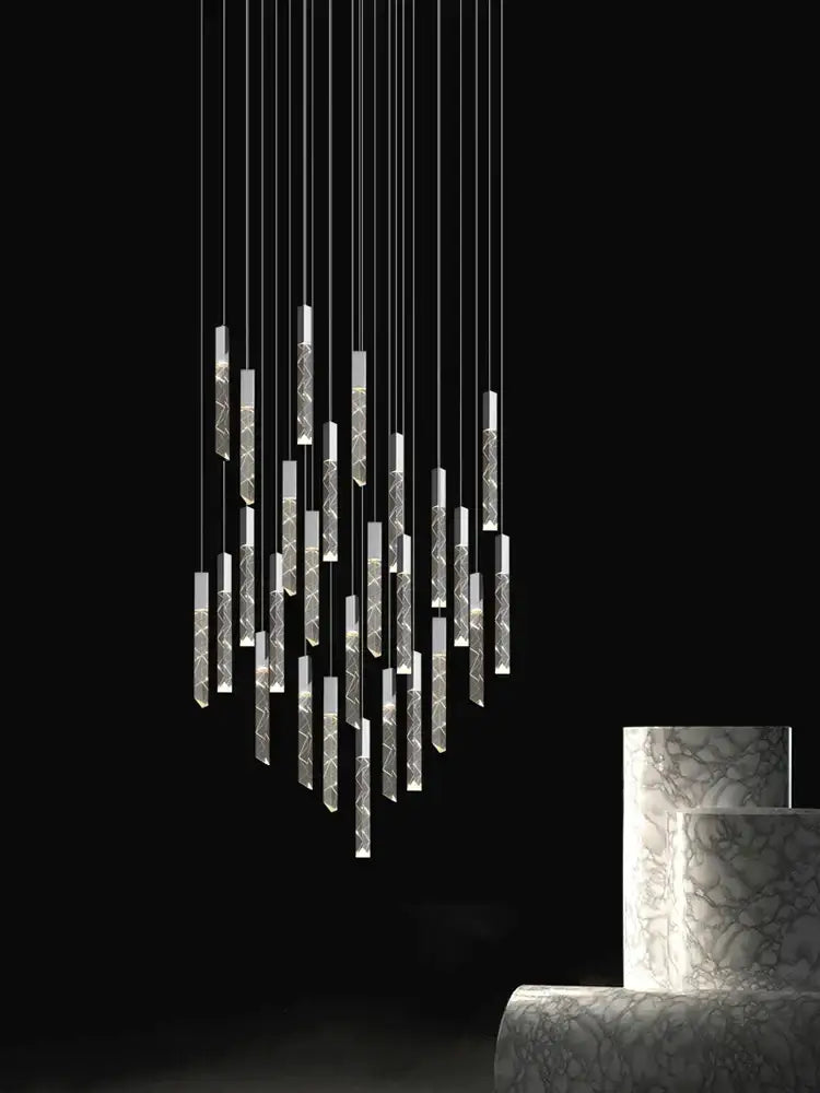 Modern minimalist crystal chrome led chandelier featuring slender etched cylindrical elements with warm ambient lighting