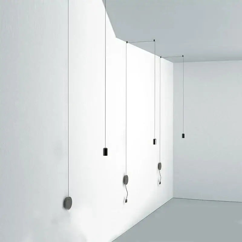Minimalist black rope pendant lamp with cylindrical lights suspended from white ceiling for modern decorbites decor