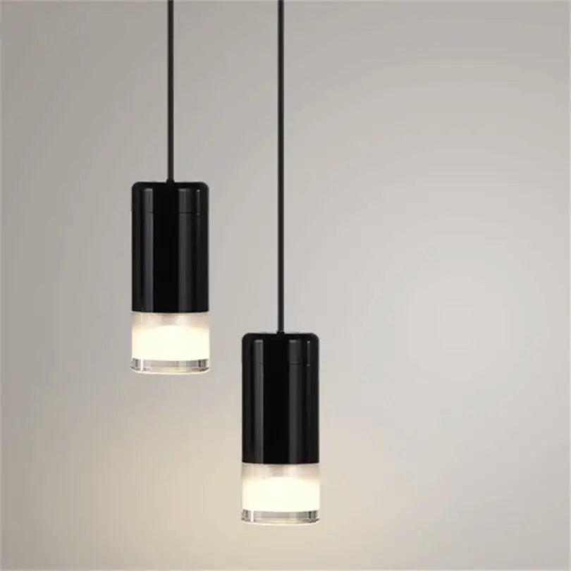Two sleek black cylindrical decorbites black rope pendant lamps with frosted glass bases for modern minimalist living room lighting
