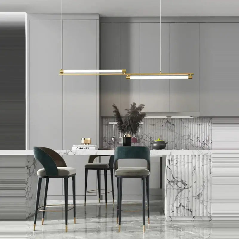 Modern minimalist dimmable led acryl chandelier with gold-toned linear design hanging above marble kitchen island